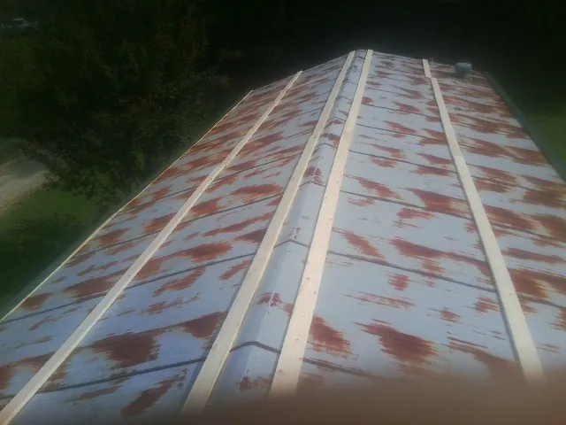 Rusted metal roof panels with new wood purlins before replacement — Storm Damage Roof Repair in Saint Peter by Roofing Brothers